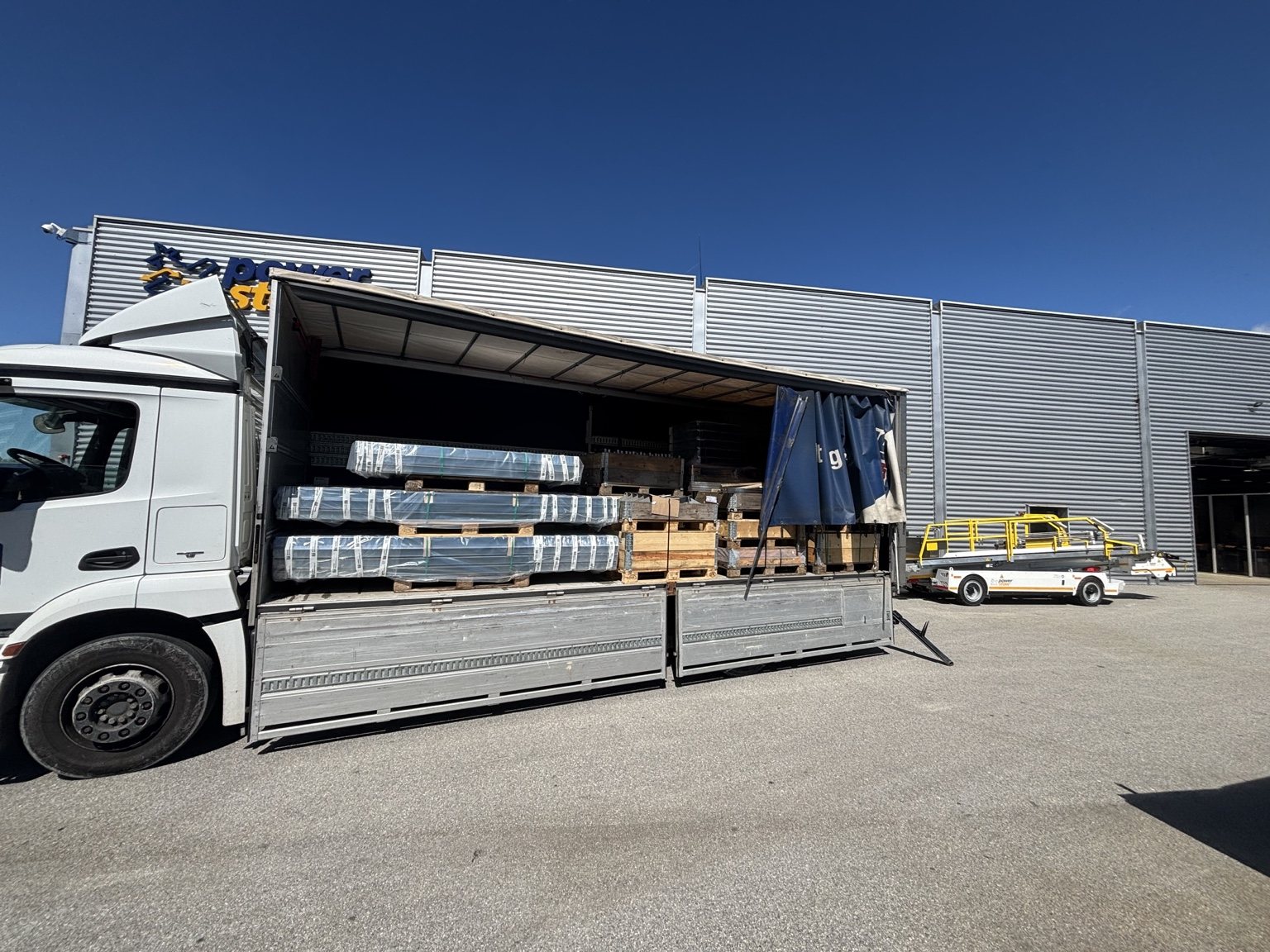 Madsen Transport lastbil med åben side og gods klar til transport